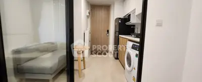 Modern apartment with compact living room and kitchen featuring washing machine and microwave.