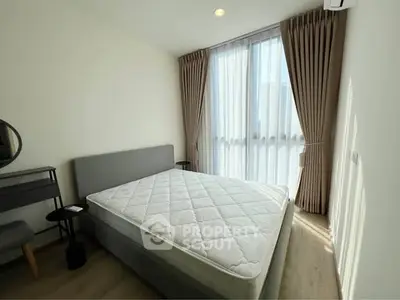 Bright and airy bedroom with large window and modern furnishings