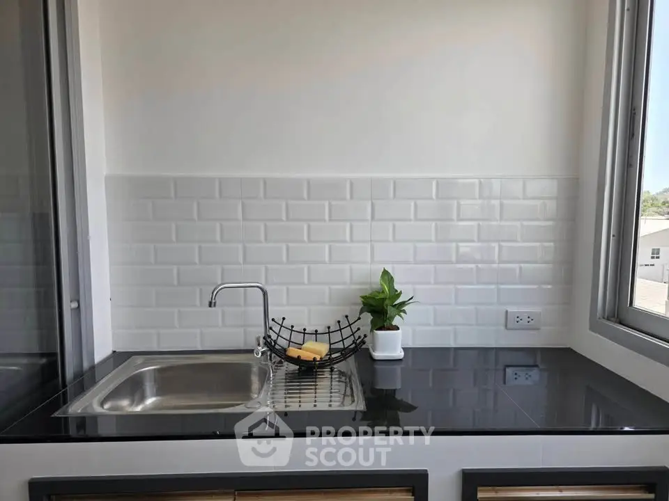 Modern kitchen with sleek black countertop and stainless steel sink