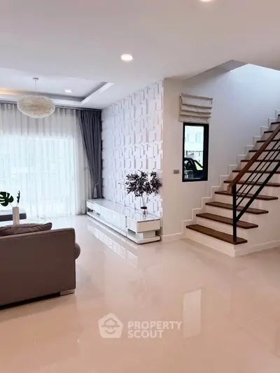 Spacious modern living room with elegant staircase and natural light