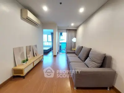 Modern living room with sleek design, featuring a comfortable gray sofa and stylish decor, perfect for urban living.