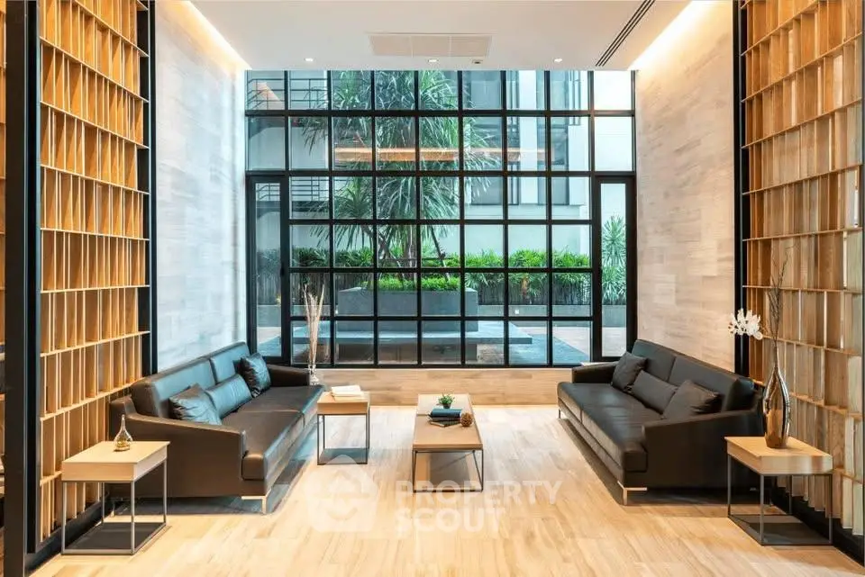 Luxurious modern living room with elegant sofas and large windows overlooking a lush garden.