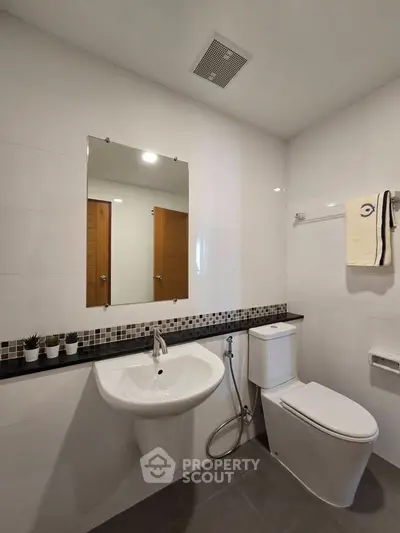 Modern bathroom with sleek fixtures and stylish tile accents in a contemporary home.