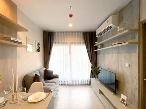 Modern living room with sleek design, featuring a cozy sofa, wall-mounted TV, and elegant decor.