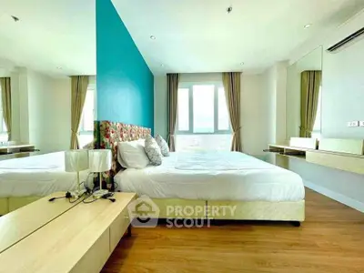 Spacious modern bedroom with stylish decor and large windows