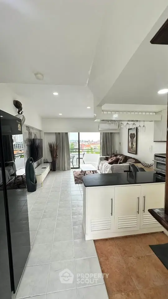 Spacious open-plan living room with modern decor and large windows offering a stunning view.