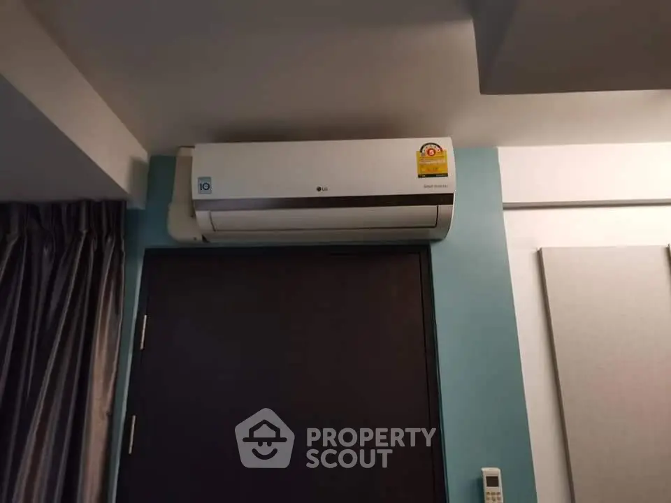 Modern air conditioning unit installed in a stylish interior room with curtains and remote control.