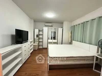Spacious bedroom with modern furniture and ample storage in a stylish apartment.
