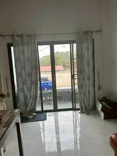 Bright living room with large sliding glass doors leading to a balcony, offering natural light and outdoor access.