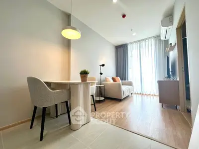 Modern living room with cozy seating and stylish dining area, featuring natural light and elegant decor.