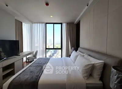 Luxurious bedroom with modern decor and stunning city view, featuring a large bed and sleek furnishings.