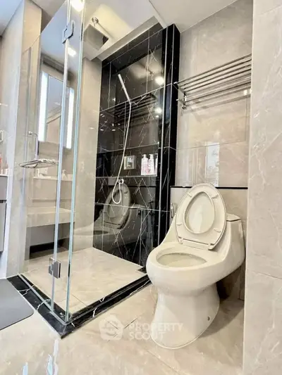 Luxurious modern bathroom with sleek glass shower and elegant marble accents.