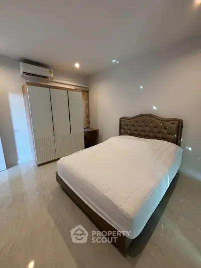 Cozy bedroom with modern design, featuring a comfortable bed and sleek wardrobe, perfect for relaxation.