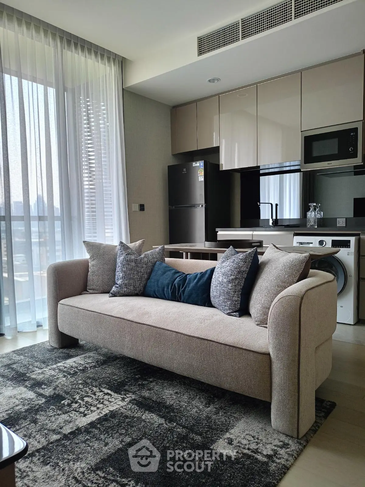 Modern living room with stylish sofa and open kitchen layout in luxury apartment
