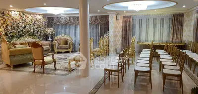 Luxurious living room with elegant gold furniture and floral decor, perfect for hosting events.