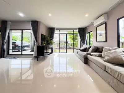 Spacious modern living room with large windows and sleek furnishings