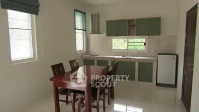 Spacious kitchen with dining area and modern appliances in a bright, airy setting.