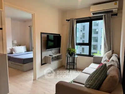 Modern living room with cozy sofa and wall-mounted TV, adjacent to a stylish bedroom with large window view.