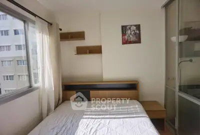 Cozy bedroom with natural light and modern decor in urban apartment.