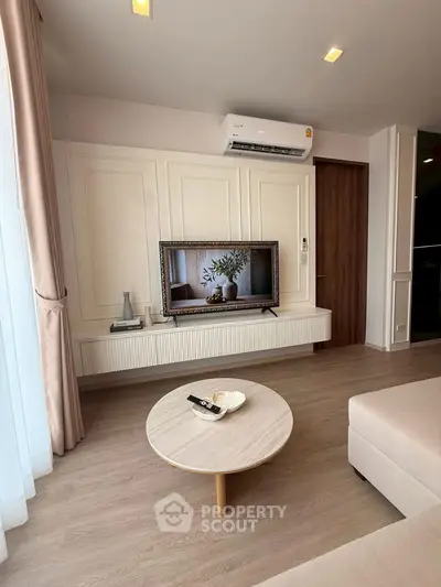 Modern living room with stylish decor, featuring a wall-mounted TV, air conditioning, and elegant furnishings.