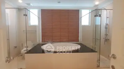 Luxurious bathroom with central bathtub and modern glass shower enclosure