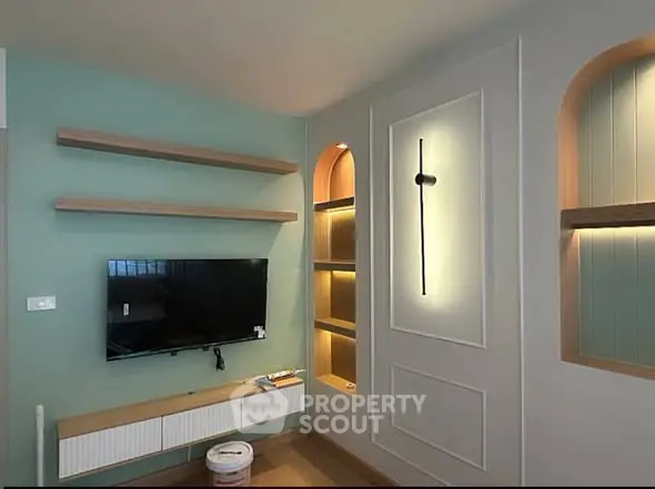 Modern living room with stylish wall shelves and mounted TV