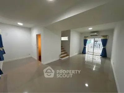 Spacious modern living room with glossy floors and large windows for natural light.