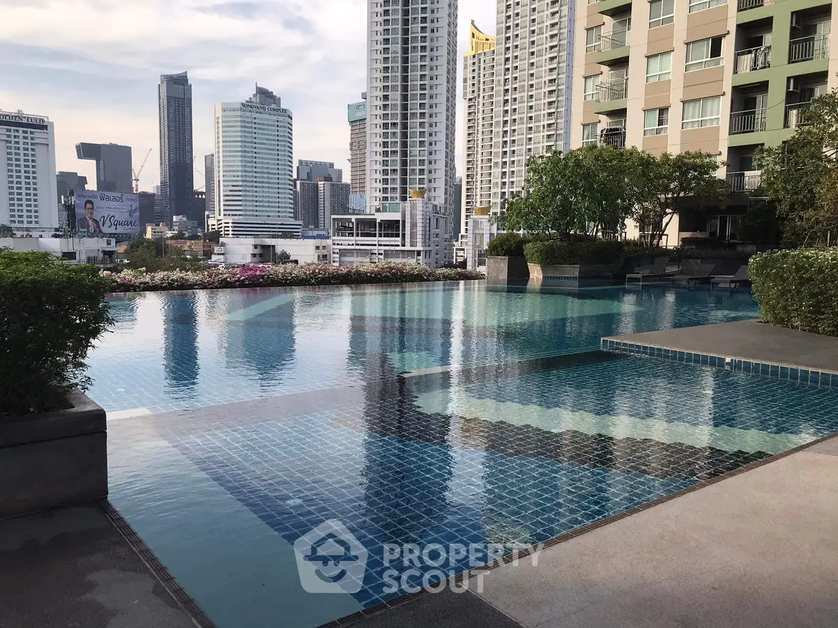 Luxurious rooftop pool with stunning city skyline views in modern high-rise building.