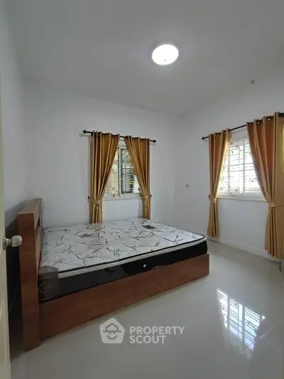 Spacious bedroom with natural light and modern furnishings