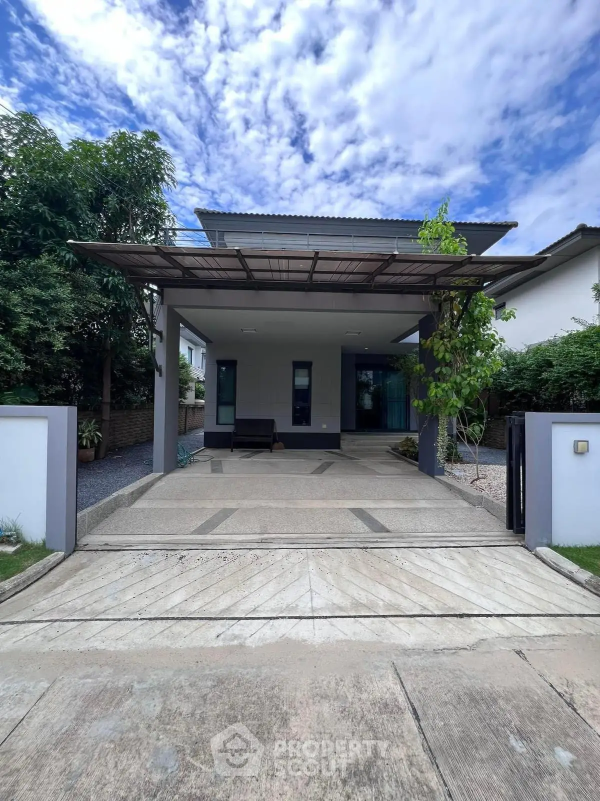 Modern single-story house with sleek driveway and lush greenery, perfect for contemporary living.