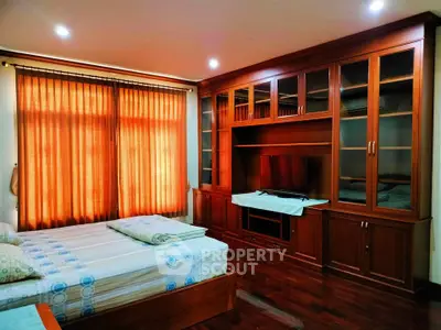 Spacious bedroom with elegant wooden cabinetry and cozy lighting