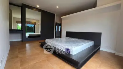 Spacious modern bedroom with large mirror and sleek design