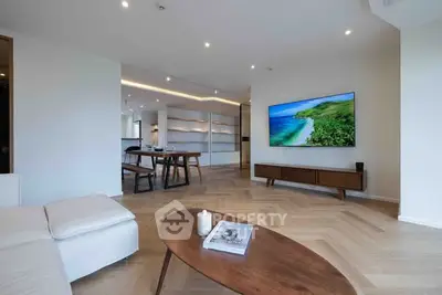 Modern living room with sleek design and large TV, featuring elegant wooden flooring.