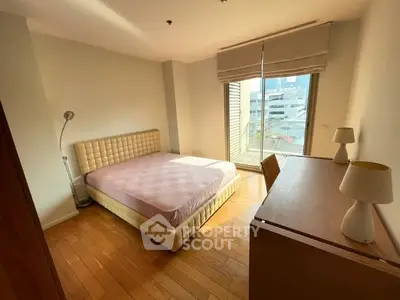 Bright and cozy bedroom with wooden flooring and large window view