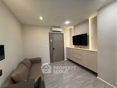 Modern living room with sleek design, featuring a wall-mounted TV and stylish furniture.