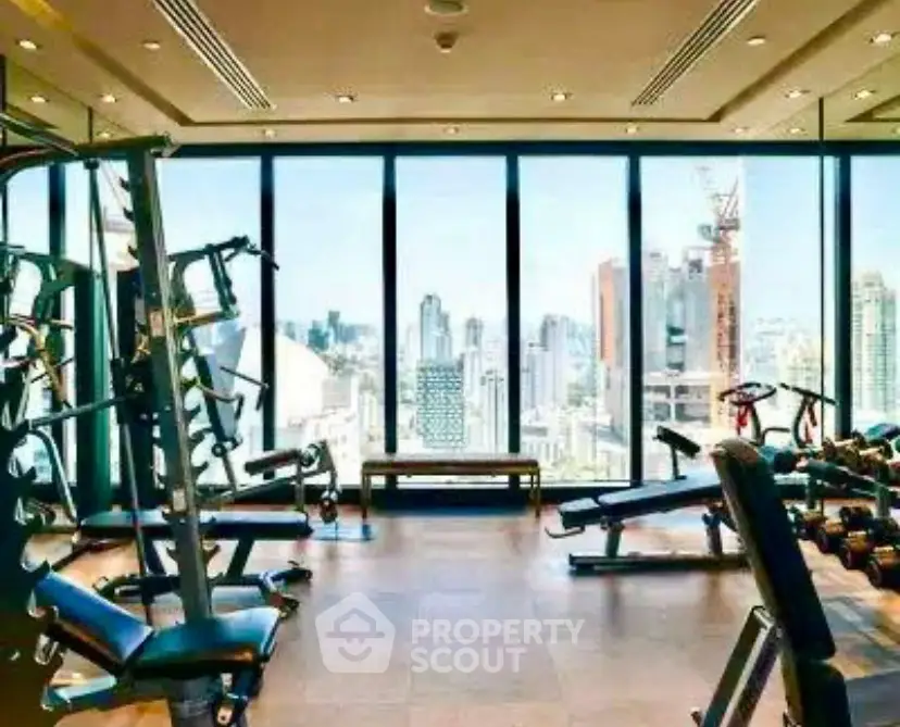 Luxurious high-rise gym with panoramic city views and modern fitness equipment.