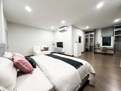 Spacious modern bedroom with stylish decor and ample natural light