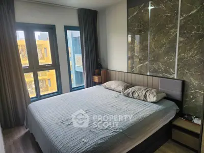 Modern bedroom with stylish decor and large windows offering natural light