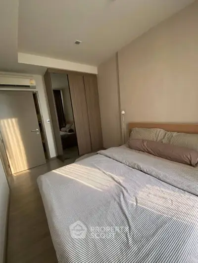 Cozy bedroom with modern design and ample natural light, featuring a comfortable bed and sleek wardrobe.