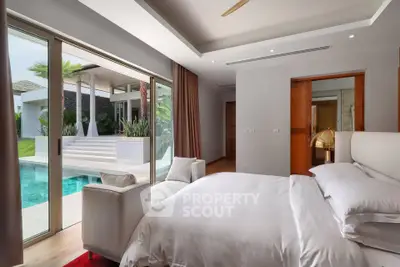 Luxurious bedroom with poolside view and modern decor in a tropical villa.