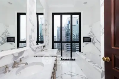 Luxurious marble bathroom with city view and elegant fixtures