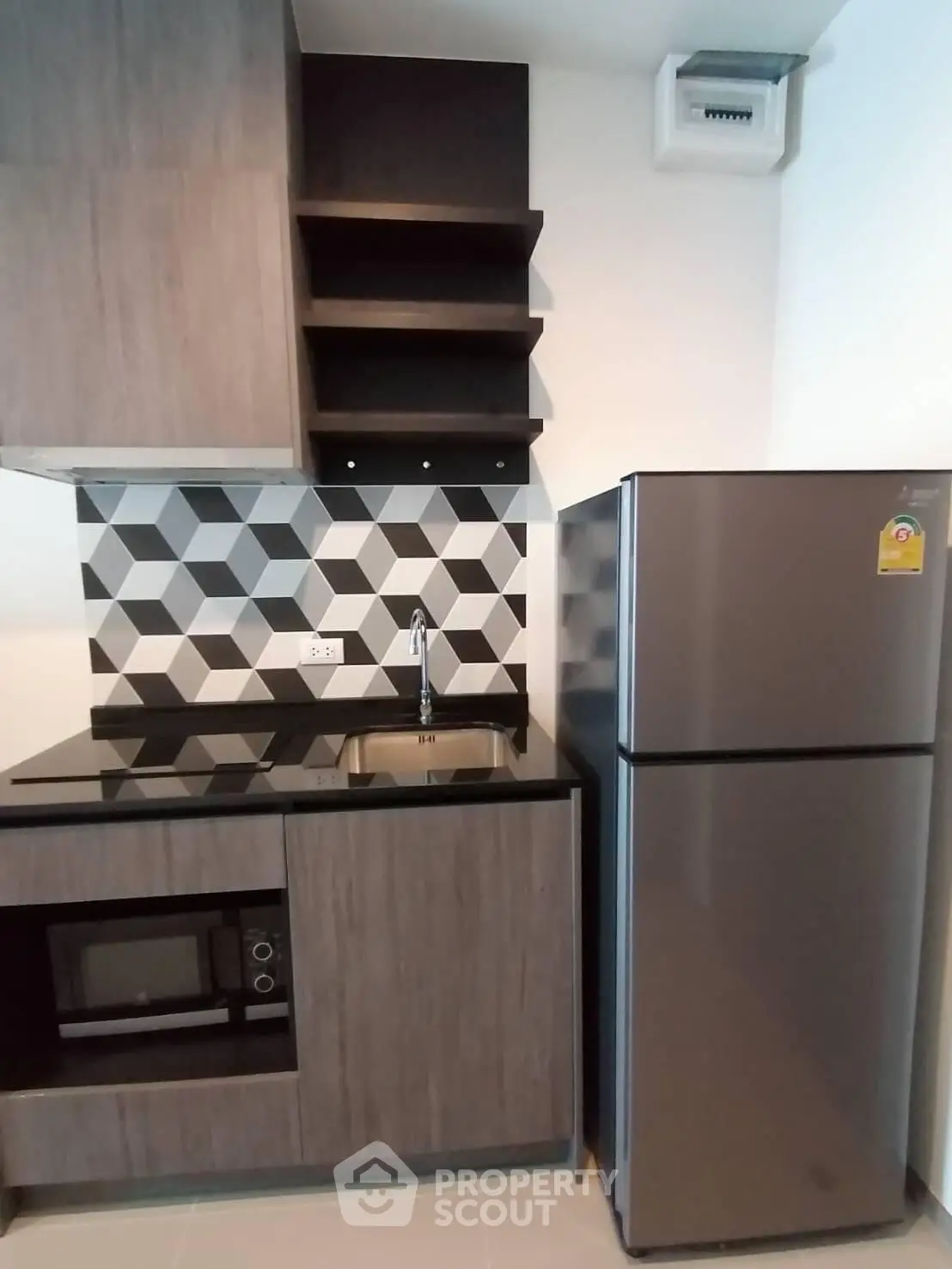 Modern kitchen with geometric backsplash, sleek cabinetry, and stainless steel appliances.