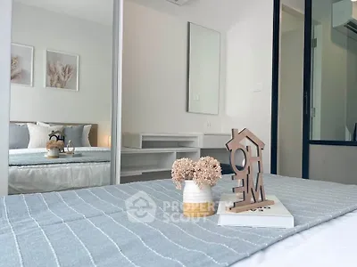 Modern bedroom with stylish decor and cozy ambiance, featuring a large mirror and elegant furnishings.