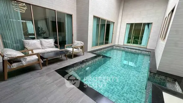 Luxurious indoor pool area with modern seating and large windows