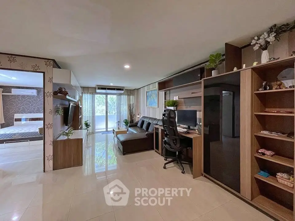 Spacious modern living room with home office setup and view of bedroom, ideal for urban living.