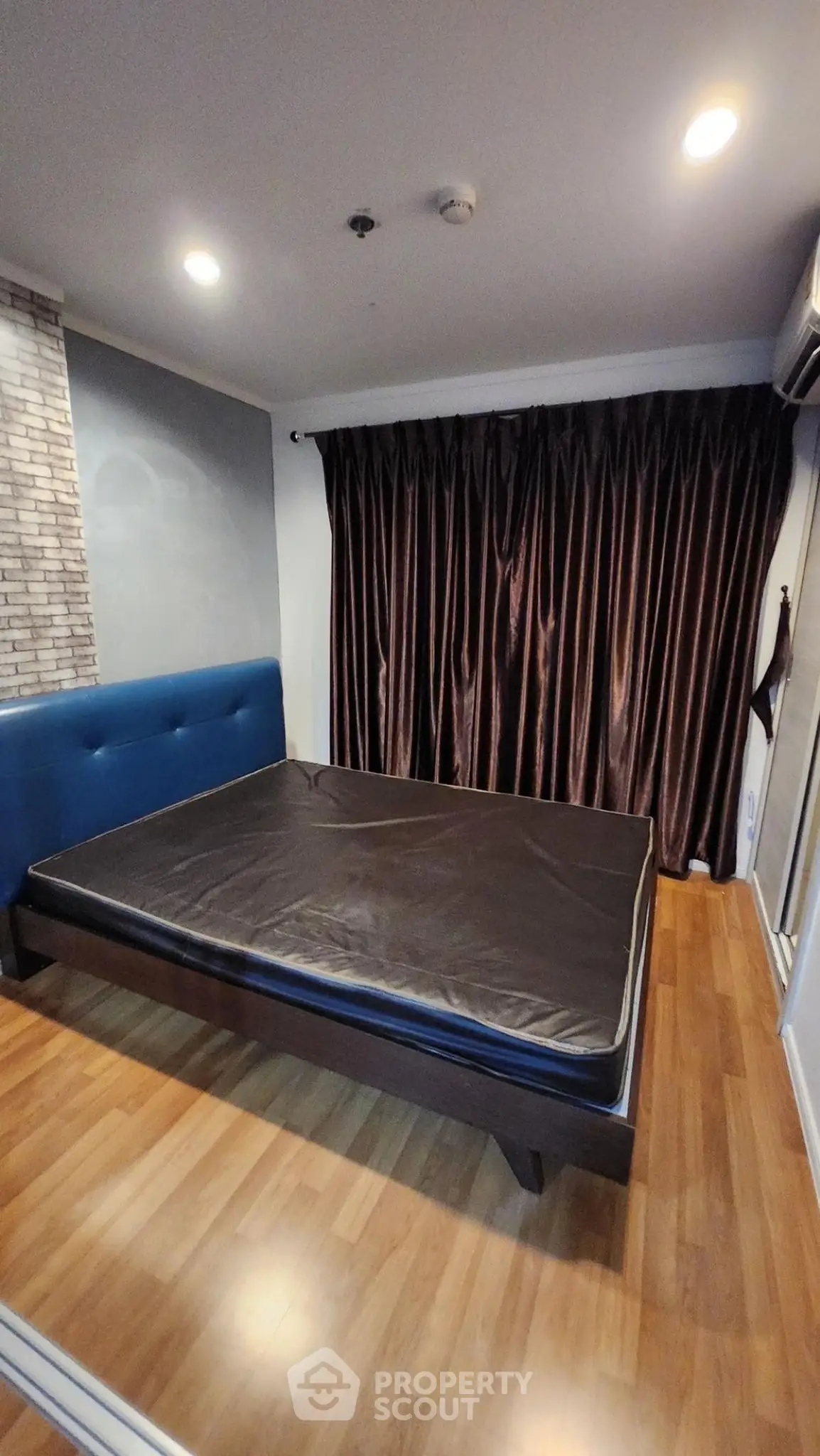 Modern bedroom with wooden flooring and stylish curtains