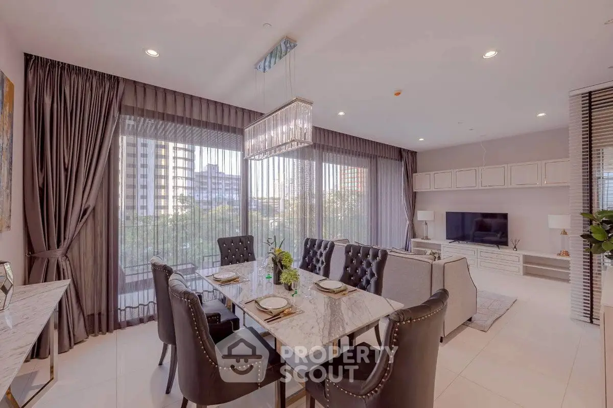 Luxurious open-plan living and dining area with elegant decor and large windows offering city views.