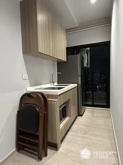 Modern kitchen with sleek cabinetry and city view from window