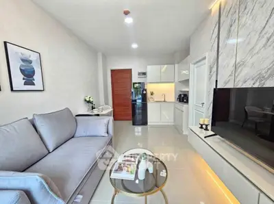 Modern living room with sleek design, featuring a cozy sofa, stylish decor, and a contemporary kitchen area.