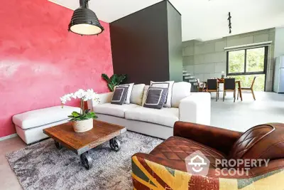 Modern living room with stylish furniture and vibrant red accent wall